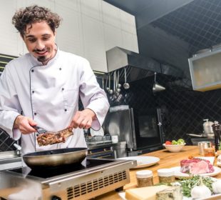 smiling-chef-frying-meat-in-restaurant-kitchen-2022-12-16-20-03-48-utc-1-905x613