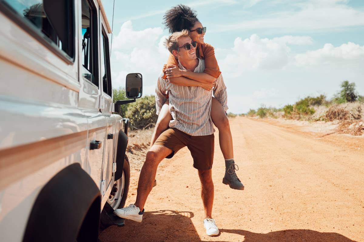 Couple piggy back on road trip in Australia, travel adventure in summer holiday and outdoor truck d.