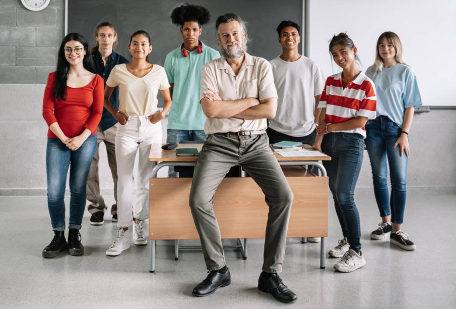 Portrait of Multi-ethnic group of teenager secondary school students and friendly teacher in the classroom of the High School. Cultural Diversity in Education and Society