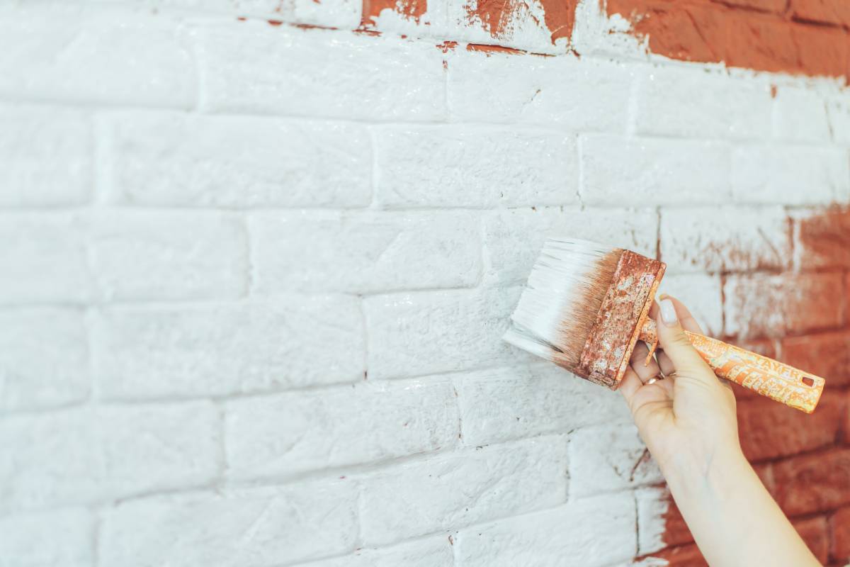 Paint brick wall white with brush.