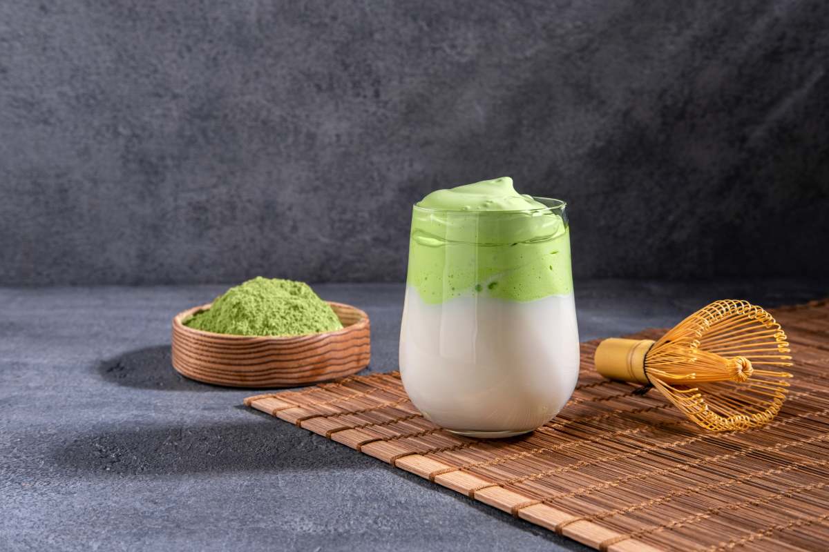 Matcha tea. Iced green tea matcha latte in glass. Green tea dalgona, whipped grean tea with milk. Healthy vegan drink, close up.