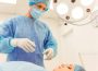 A surgeon is standing near the patient in a modern operating room, ready to perform an operation