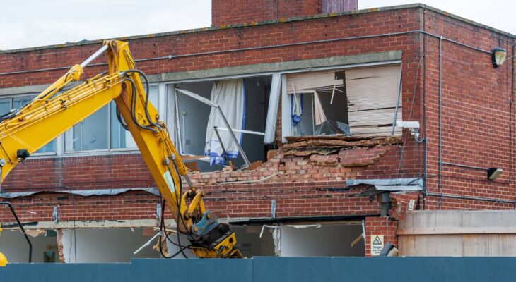 Demolition of an old building with a long reach machine hydraulic jaw. Regeneration of a space for new, modern building.