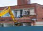 Demolition of an old building with a long reach machine hydraulic jaw. Regeneration of a space for new, modern building.